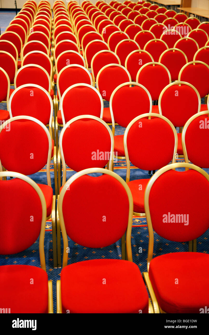 Salón de conferencias con sillas rojas en filas. Foto de stock