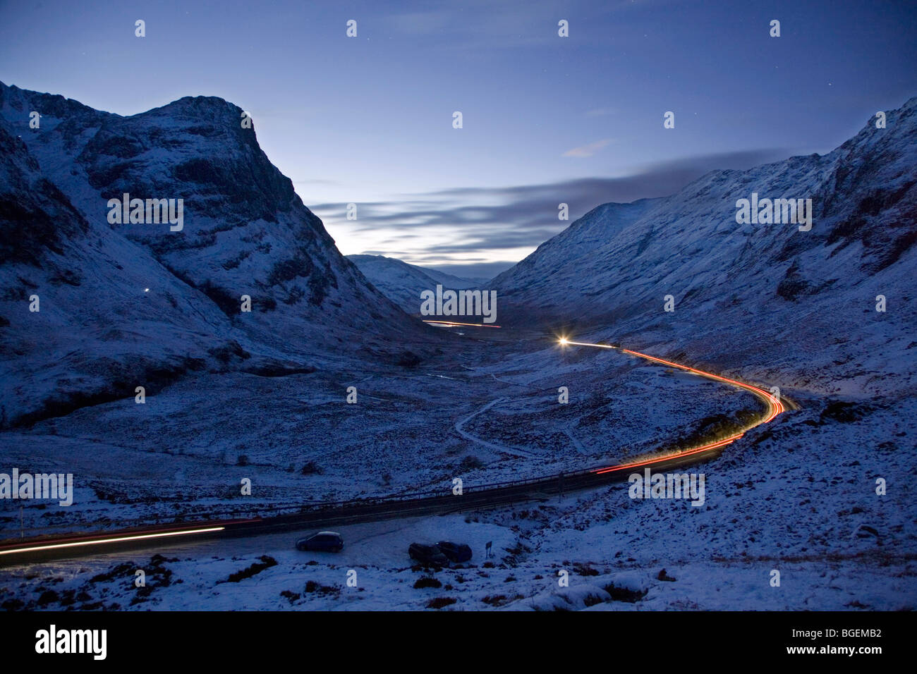 El tráfico se mueve a través del paso de Glencoe, Escocia, al caer la noche tras el final de las vacaciones de Navidad. Foto de stock