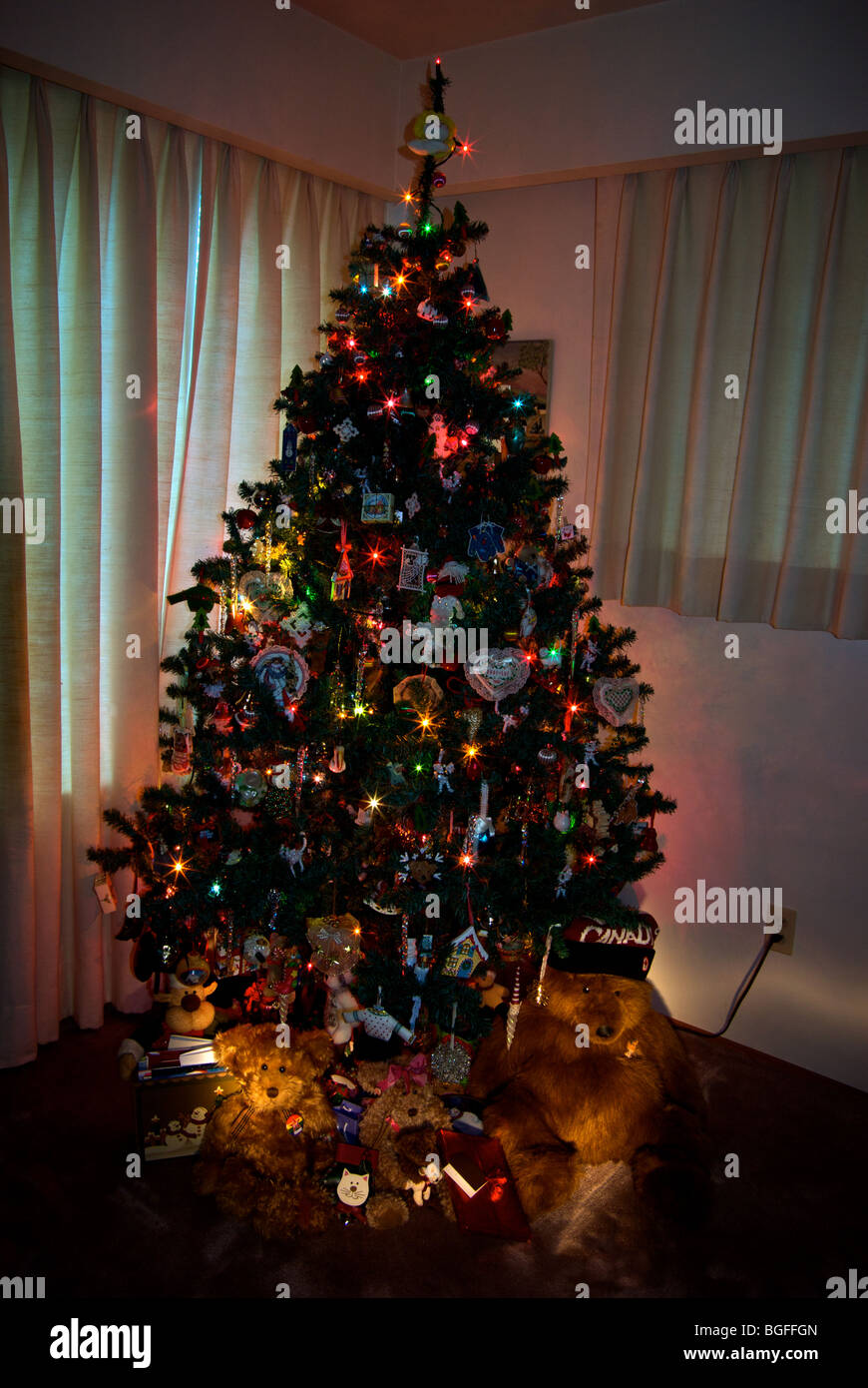 Iluminado árbol de Navidad decorado ositos de peluche presenta Foto de stock