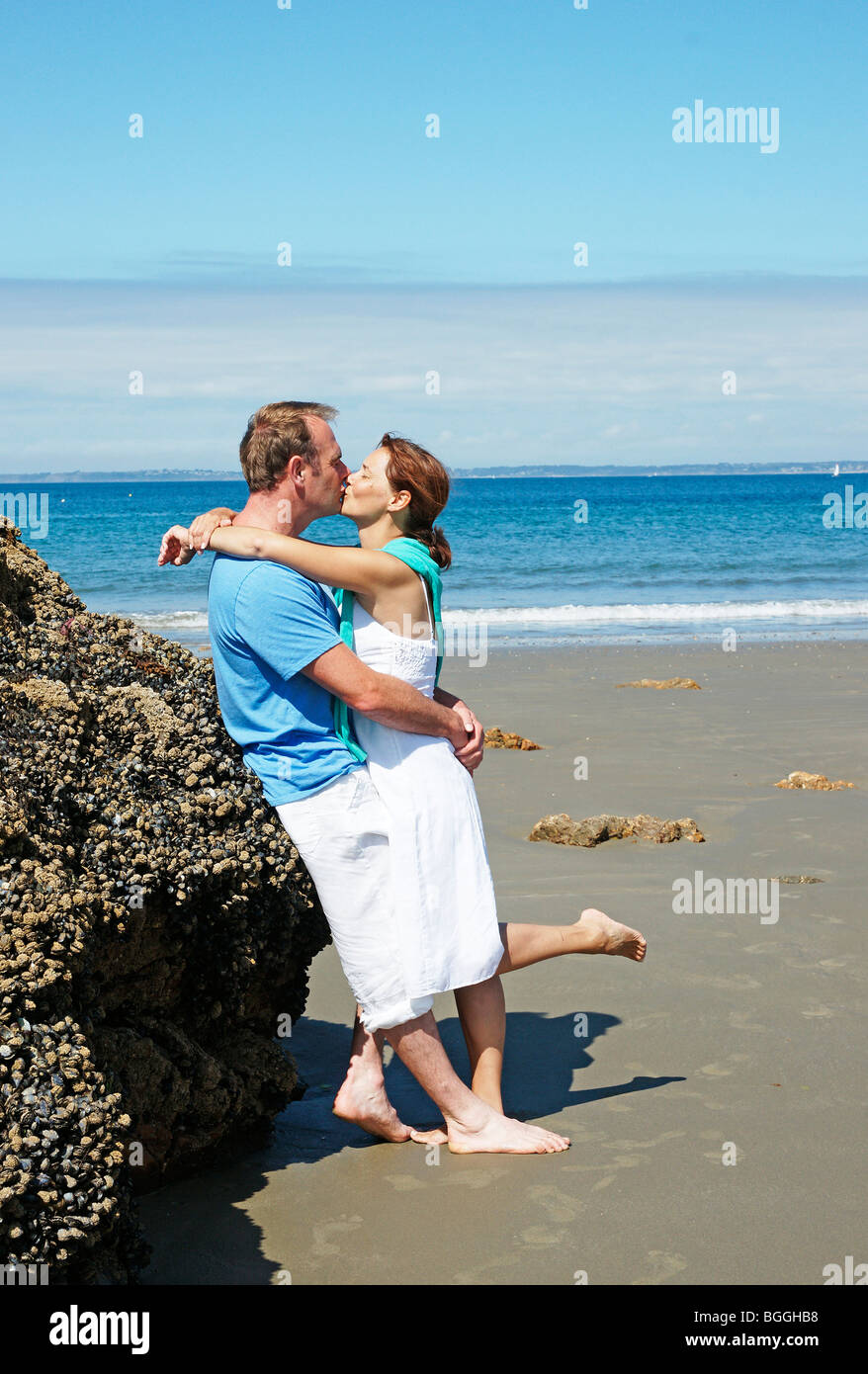 Pareja besándose en la playa, recostado contra una roca, vista lateral Fotografía de stock - Alamy Pareja besándose en la playa, recostado contra una roca, vista lateral Fotografía de stock - Alamy