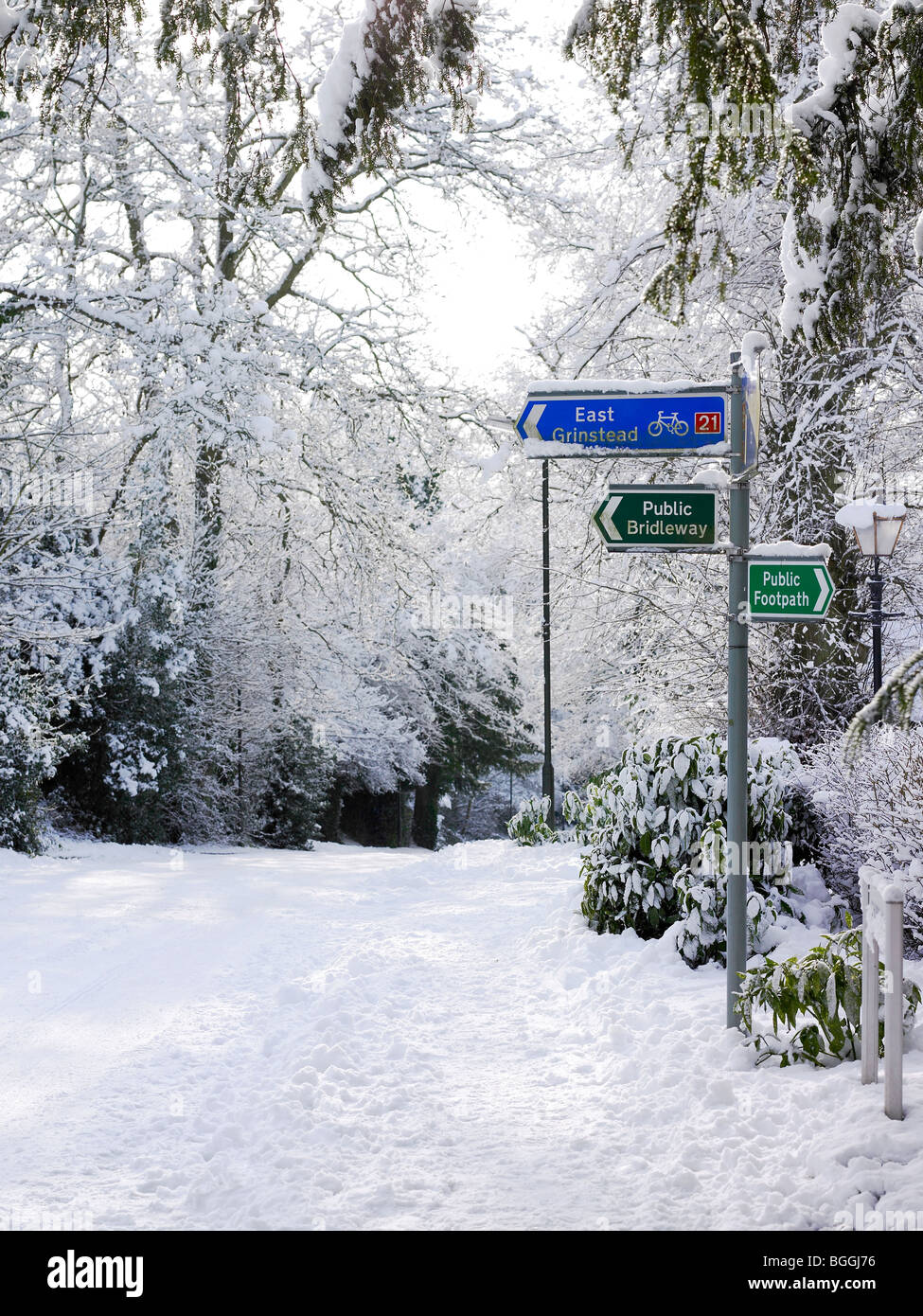 Un poste de señalización un ciclo vía, vía pública y bridleway en la nieve. Foto de stock