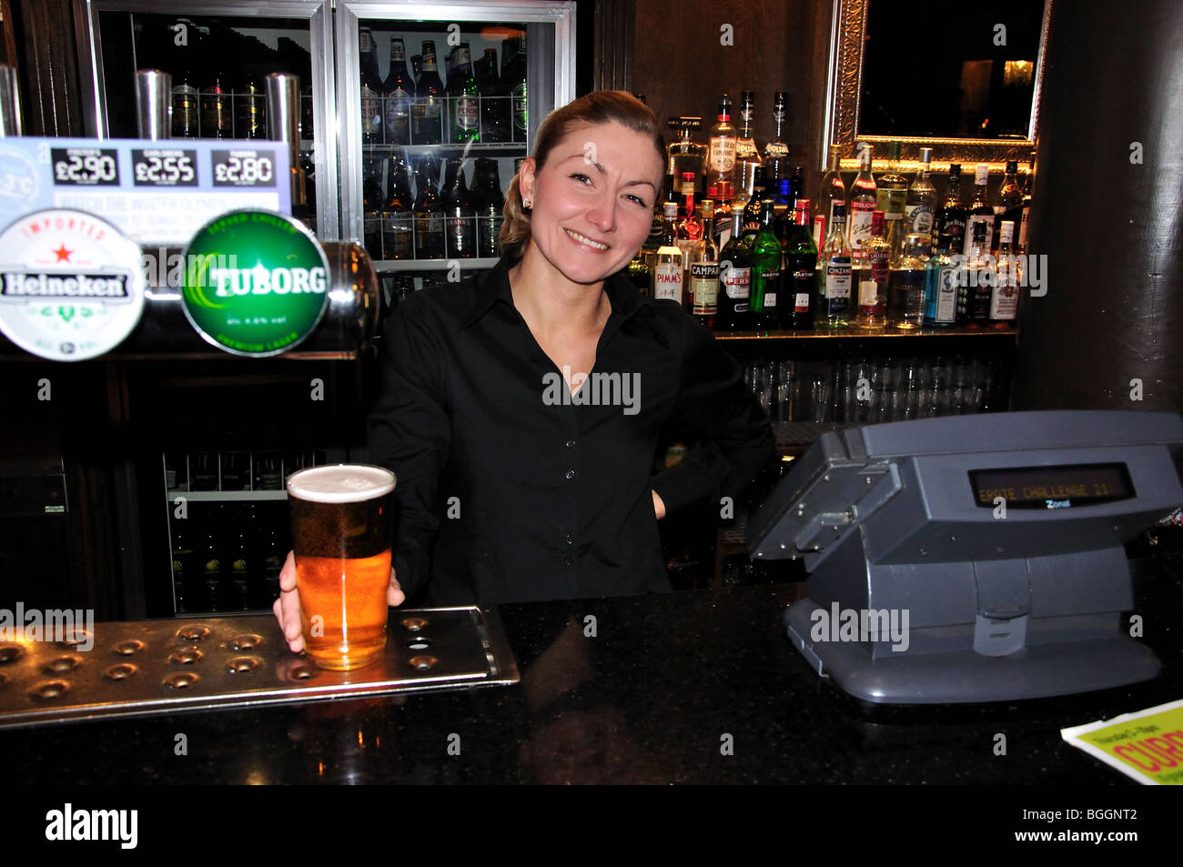 La camarera trabajando detrás de la barra, el Castillo King & Pub, Thames Street, Windsor, Berkshire, Inglaterra, Reino Unido Foto de stock