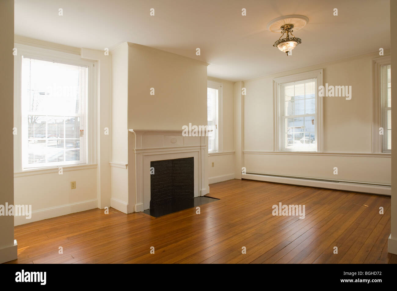 La habitación vacía en el apartamento con piso de madera y chimenea Foto de stock