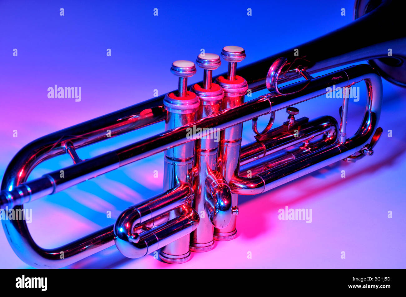 Trompeta bajo la iluminación en color mostrando las válvulas y tubos. Foto de stock