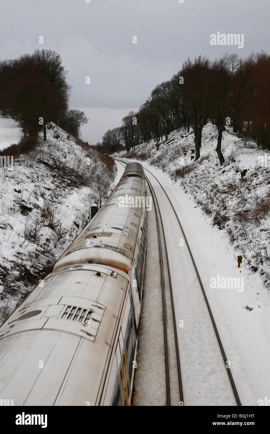 Un tren corriendo a través de la campiña de Kent nevado invierno en Inglaterra Foto de stock