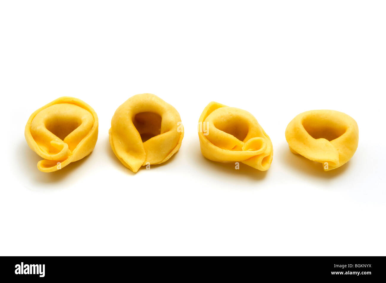 Tortellini (anillo en forma de pasta) sobre un fondo blanco. Foto de stock