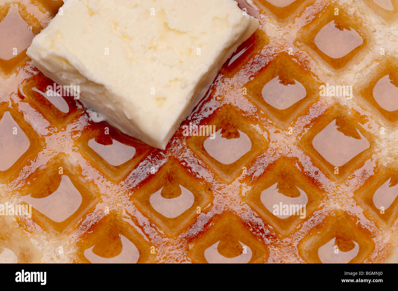 Macro de un waffle con mantequilla y jarabe de arce Foto de stock