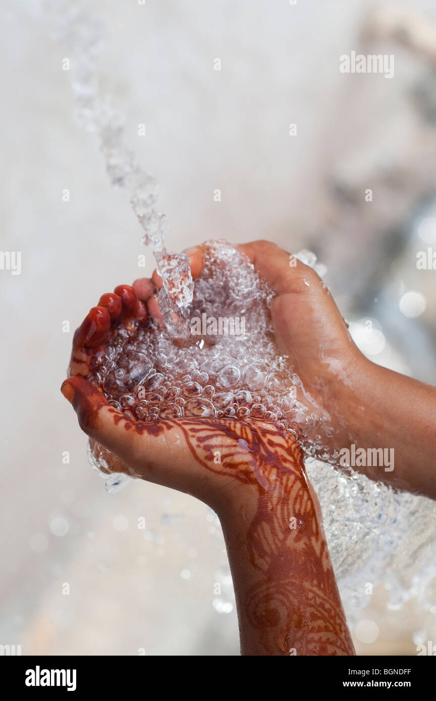 Indian childs ahuecada manos cogiendo agua servida. La India Foto de stock