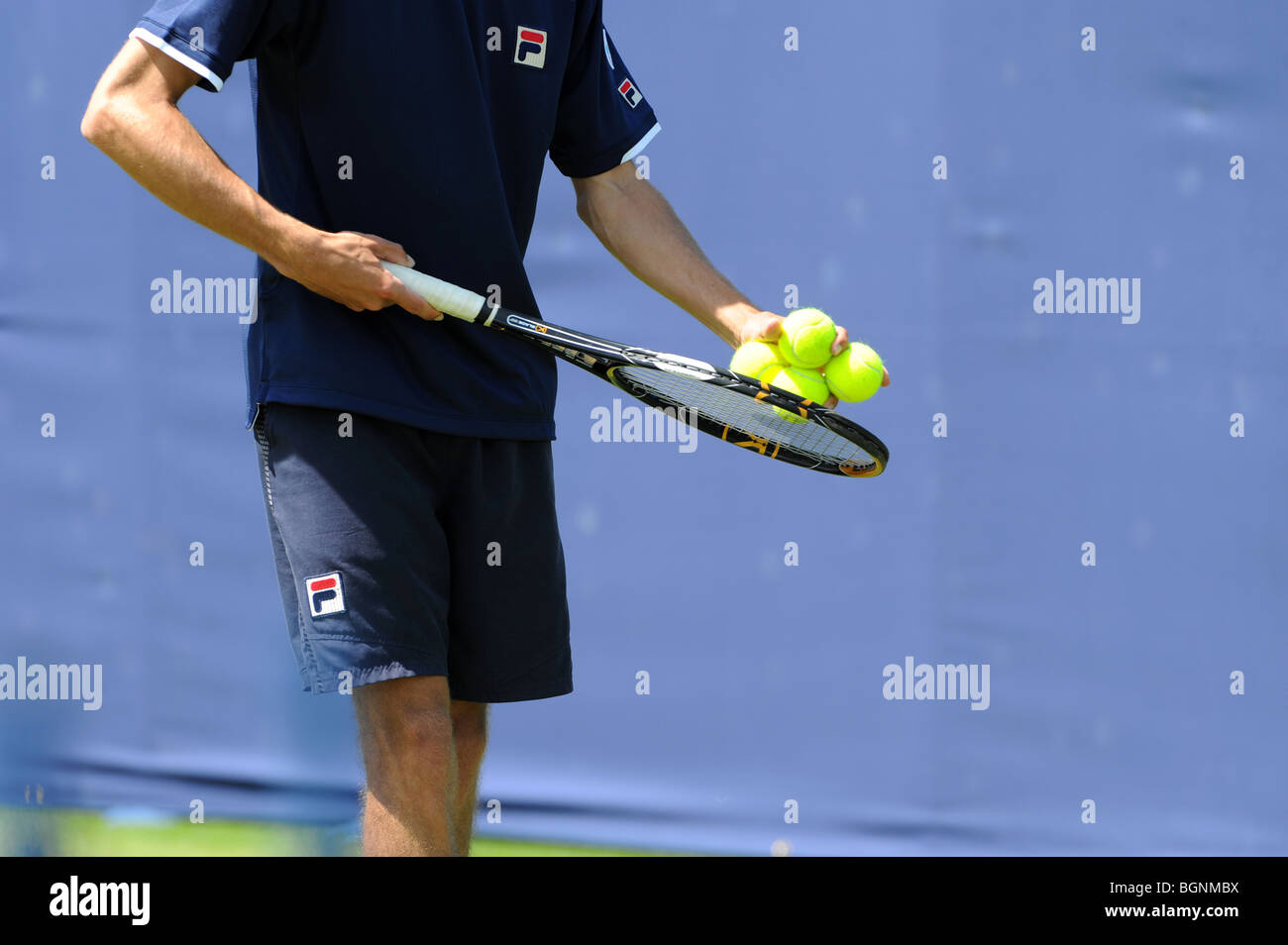Un jugador de tenis pruebas las bolas antes de servir Foto de stock