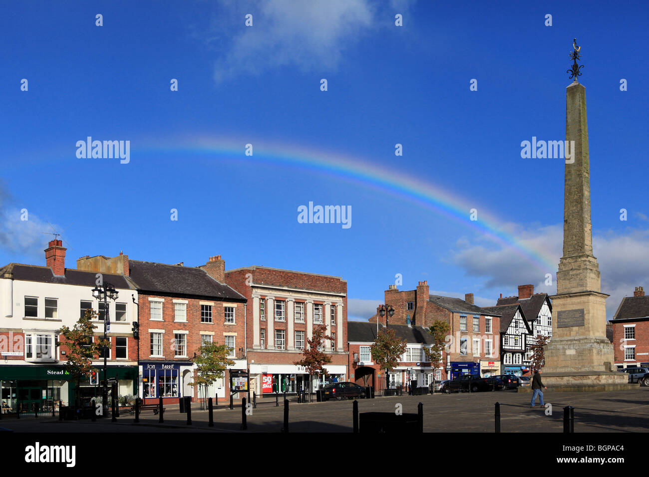 Un arco iris que brilla en un cielo azul sobre la plaza del mercado de la ciudad de Ripon. Foto de stock
