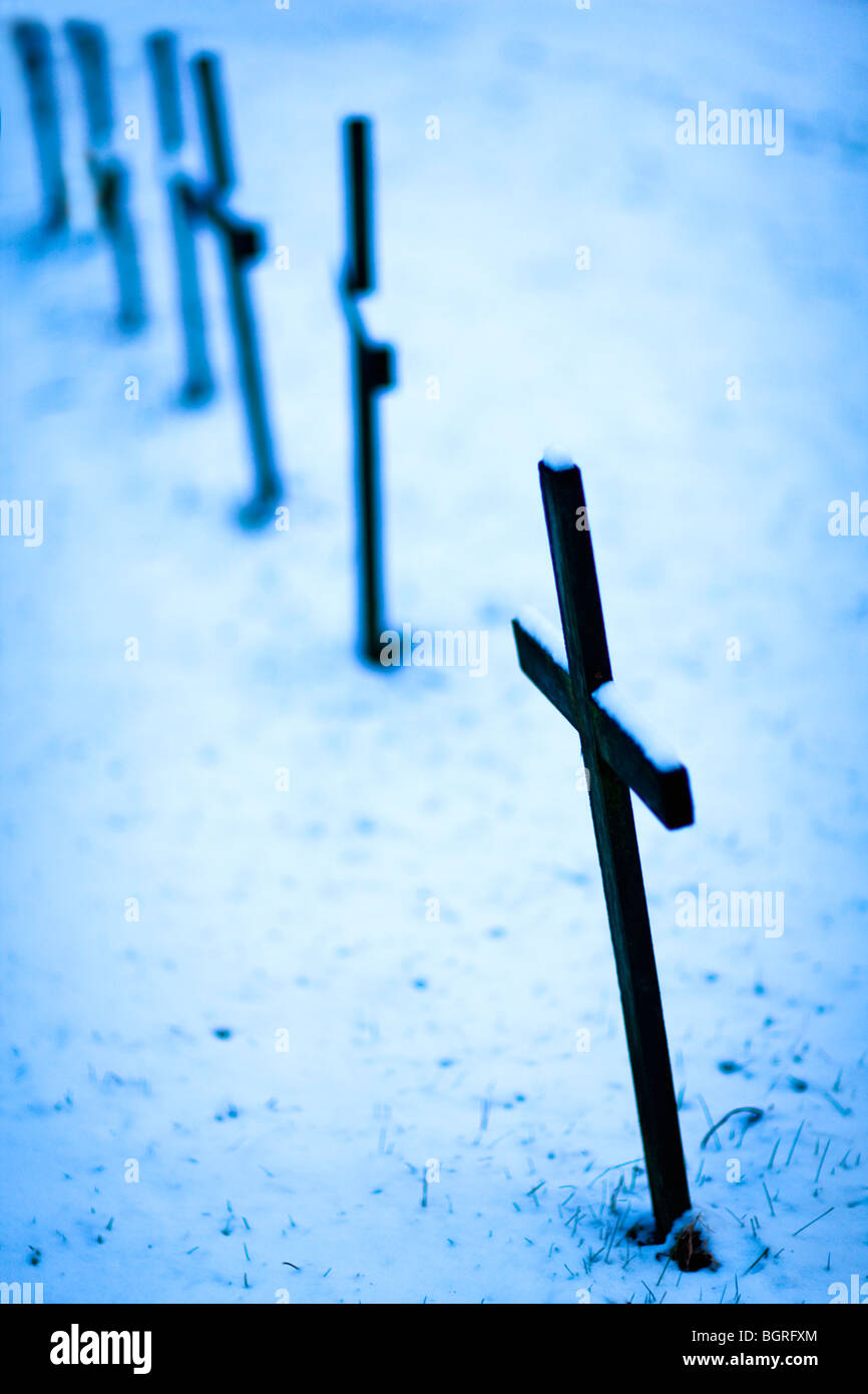 Cruz en tumbas contra la nieve, Suecia. Foto de stock