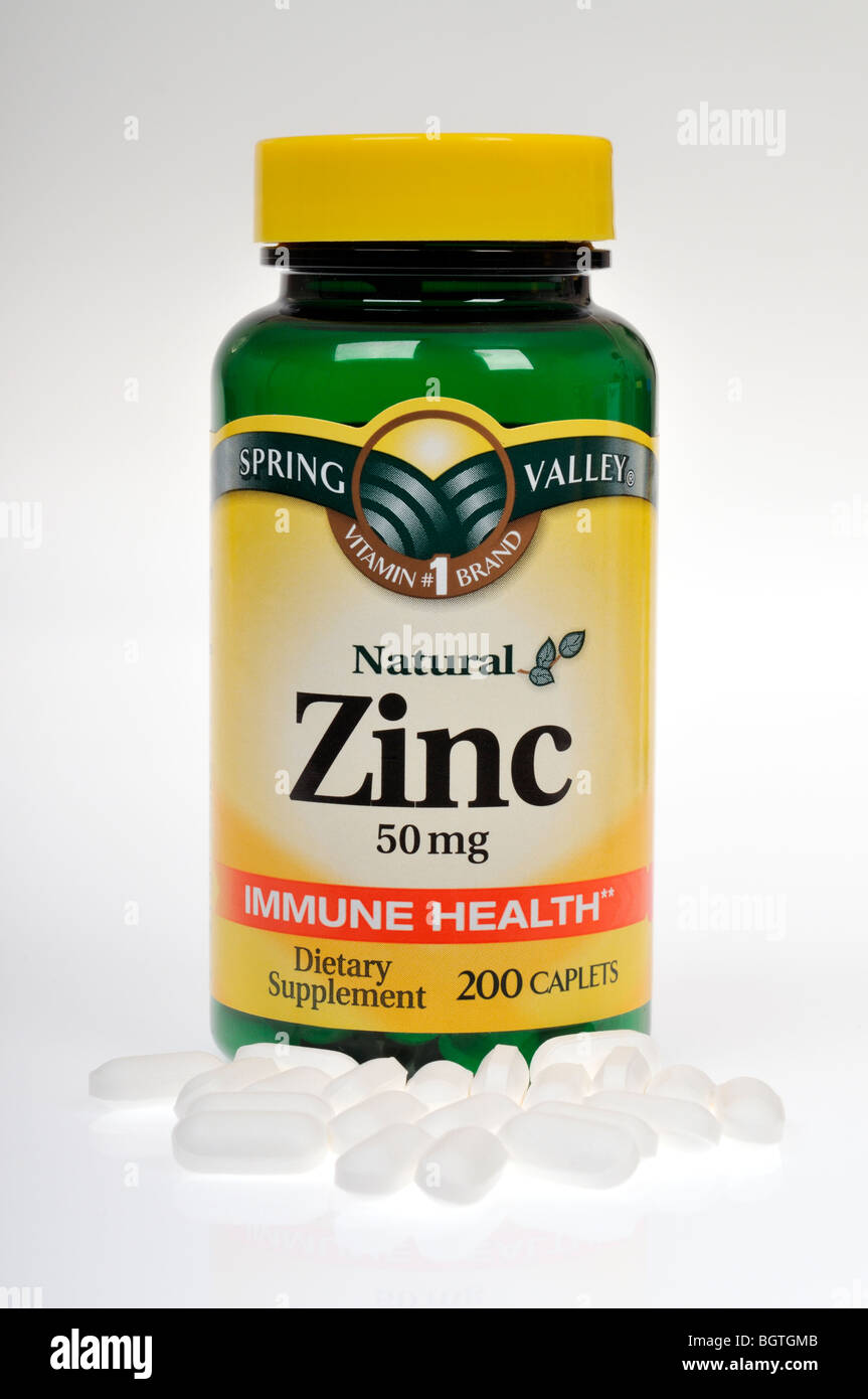 Blanco y botella de tabletas de zinc suplemento dietético sobre fondo blanco, recorte. Foto de stock