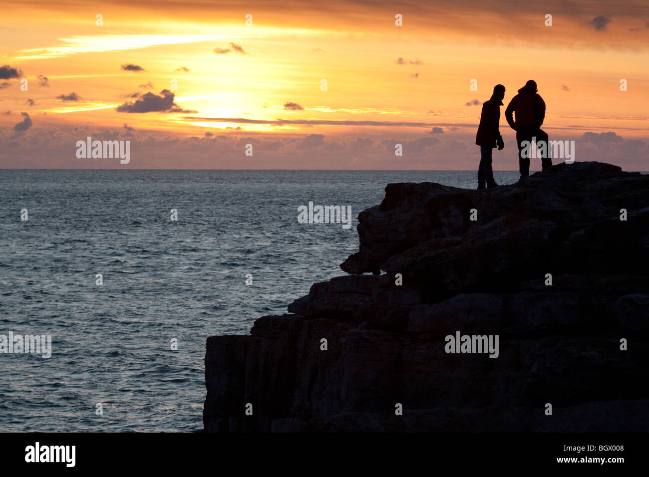 Dos hombres miran al mar desde Portland Bill, Isla de Pórtland, Dorset, Inglaterra, Reino Unido Foto de stock