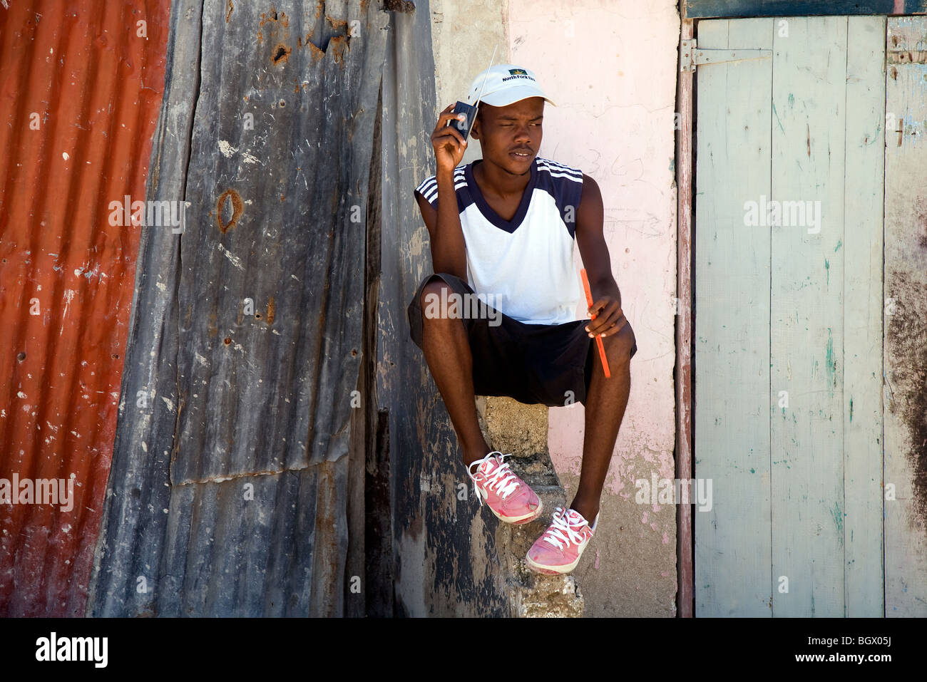Un joven residente local de Port-au-Prince, Haití, escuchar su radio  transistor en frente de su casa en la carretera de Carrefour Fotografía de  stock - Alamy