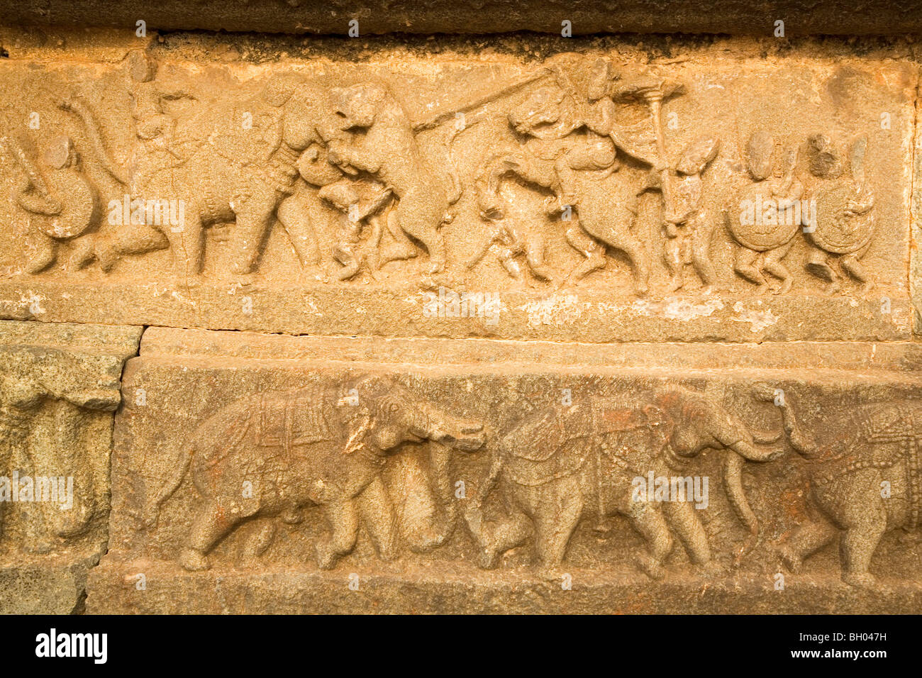 Bajorrelieves con escenas de caza que data de la época del Imperio Vijayanagar están tallados en el Mahanavmi Dibba en Hampi, India. Foto de stock