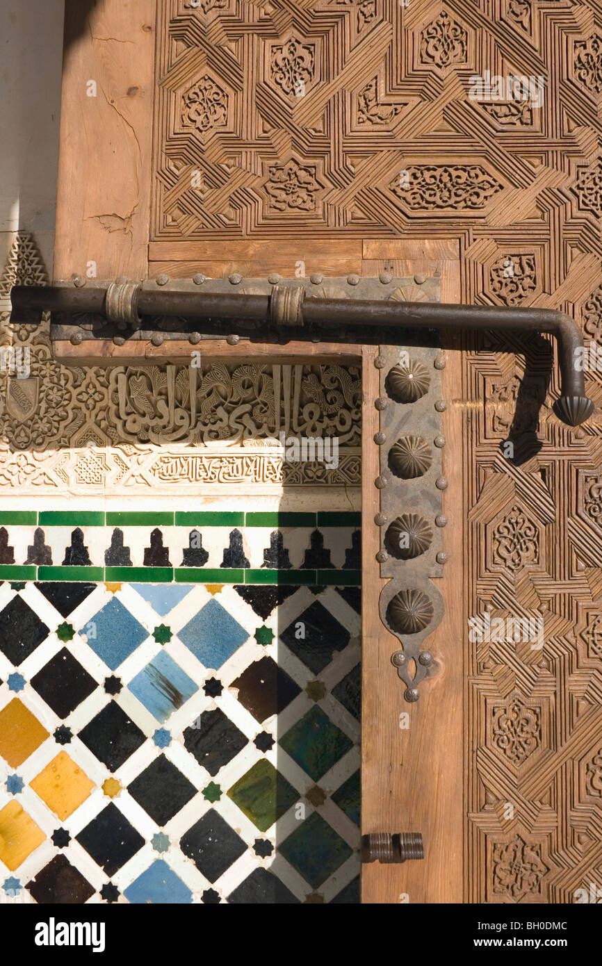 Palacio de la Alhambra, Granada, Andalucía, España. Detalle de la puerta de madera tallada, el tornillo y la pared. Foto de stock