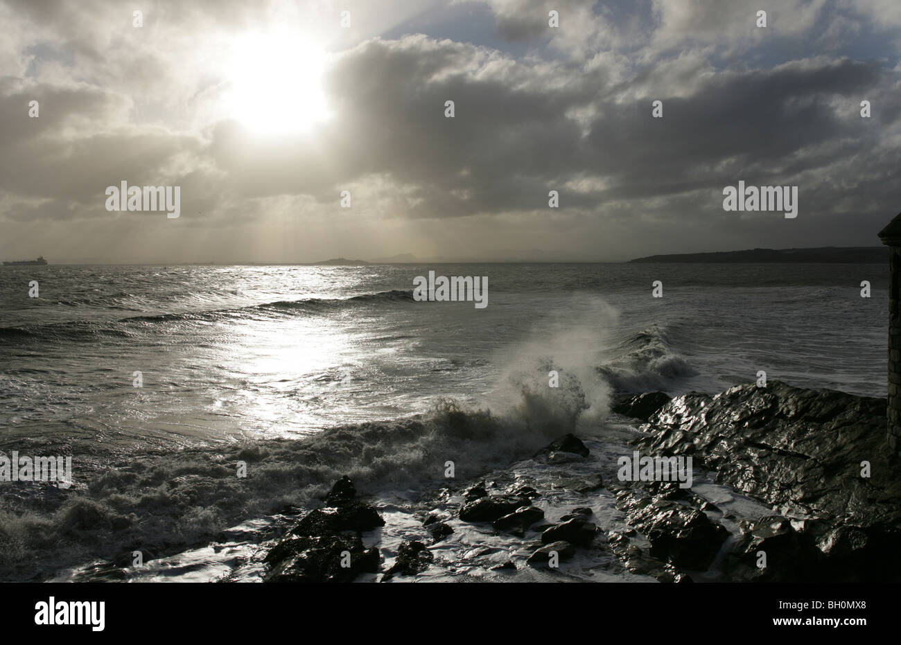 Cielos dramáticos y las olas rompiendo sobre las rocas en el Parque Ravenscraig cerca de Kirkcaldy Fife Foto de stock