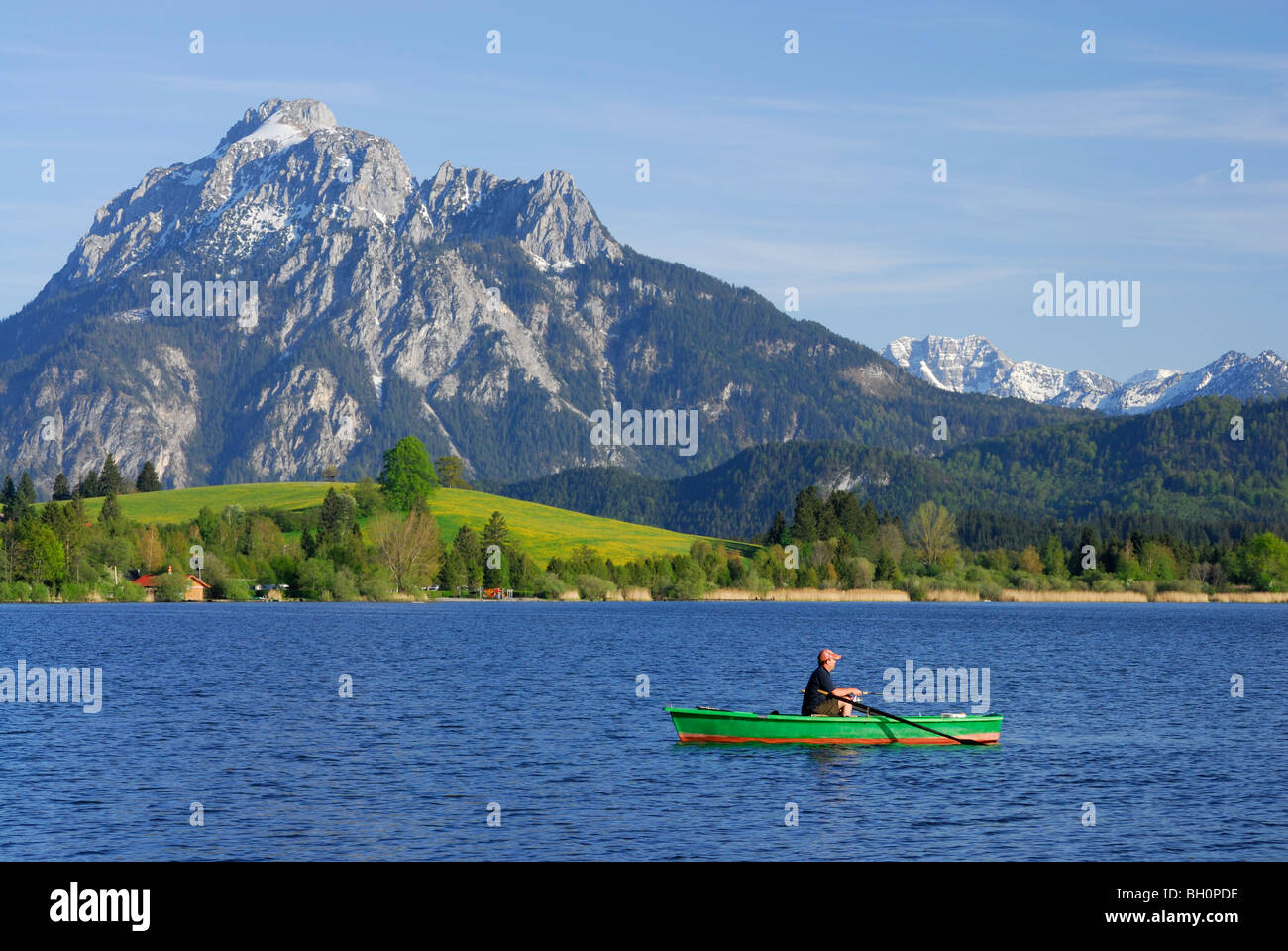 Lancha en el lago Hopfensee Saeuling con montaje en fondo, Allgaeu, suabia, Baviera, Alemania Foto de stock