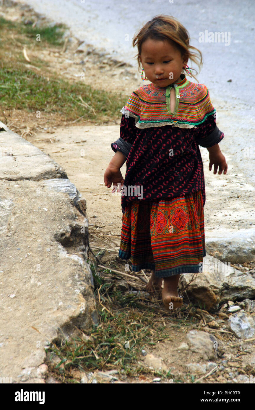 Pequeña minoría hmong kid caminando por camino de tierra sin zapatos, Lao Cai, puede cau, Vietnam del Norte. Foto de stock