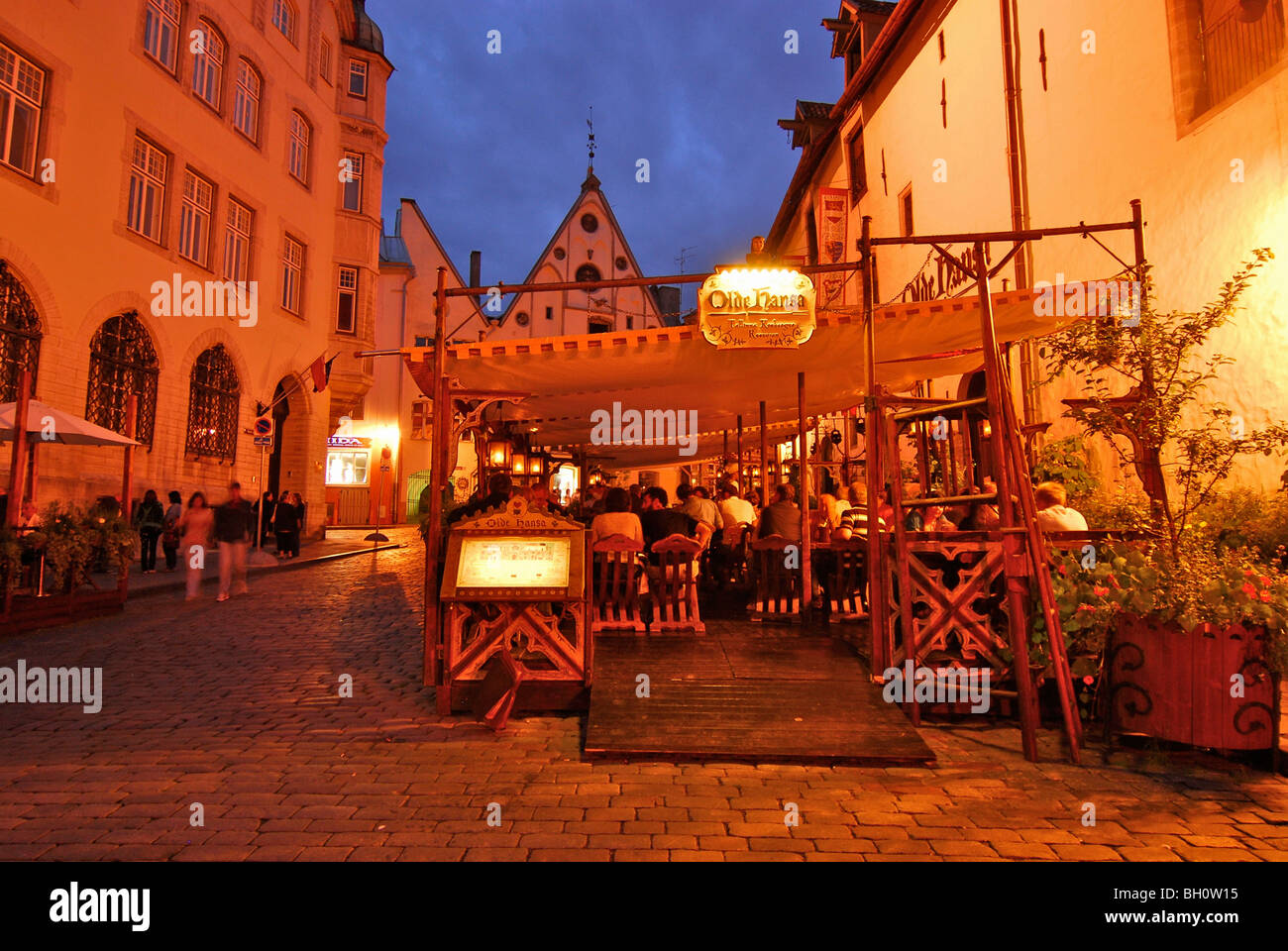Mesas fuera del restaurante Olde Hansa, que sirve platos medieval, tarde, Tallinn, Estonia Foto de stock