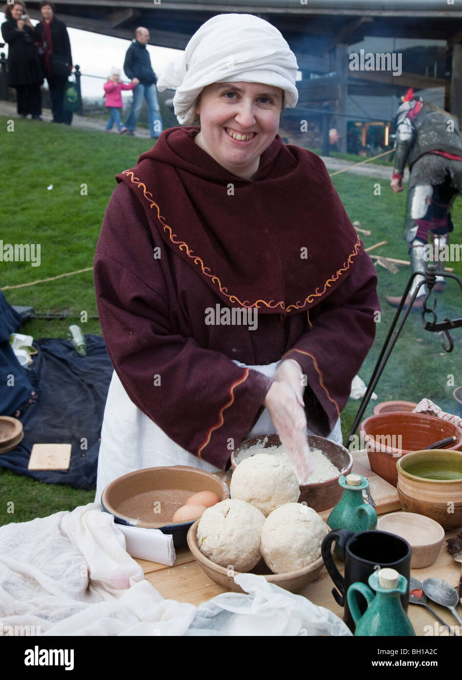 Mujer preparando dumplings en mercado de Navidad medieval Caerphilly Gales UK Foto de stock