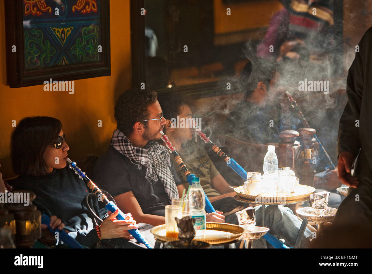 Personas fumando un waterpipe en el Cafe Fishawi en Bazar Khan el-Khalili, en El Cairo, Egipto, África Foto de stock