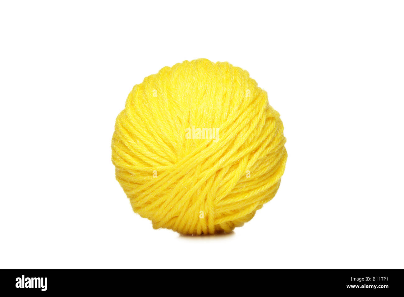 Bola de hilo amarillo sobre fondo blanco. Foto de stock