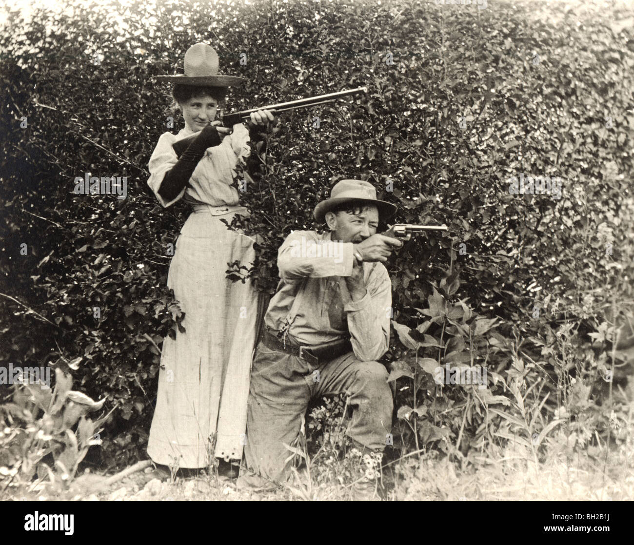 Marido y esposa armados disparando juntos Foto de stock