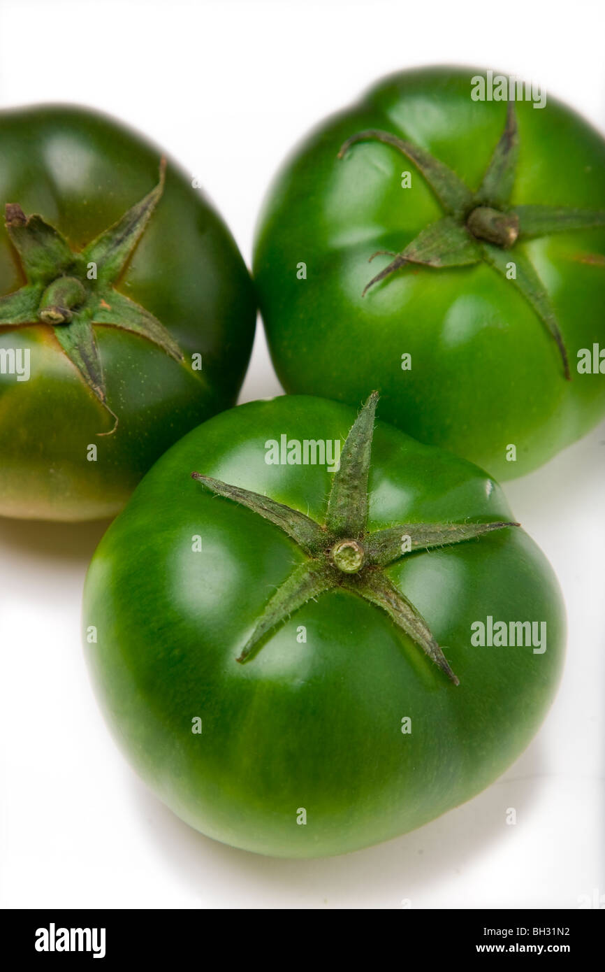 Los tomates verdes sobre un fondo blanco. Foto de stock