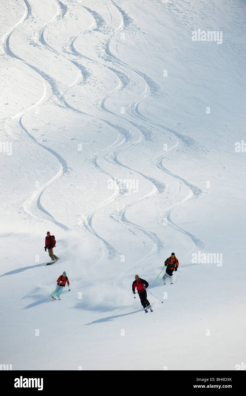 Un grupo de esquiadores de travesía siga su guía cuesta abajo en las Montañas Selkirk, Canadá. Foto de stock