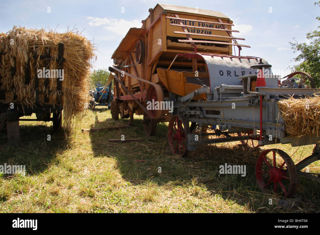 Una vieja máquina de trilla francesa está alimentado por un tractor Lanz Bulldog. Foto de stock