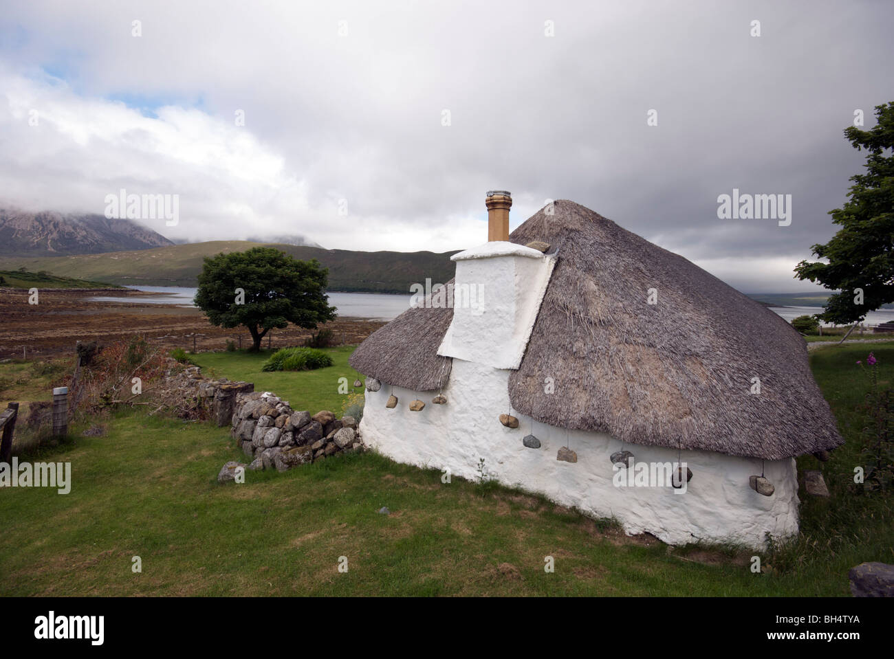 Tradicional, histórica casa con techo de paja y piedras en la Isla de con vistas a Loch Ainort Fotografía de stock - Alamy