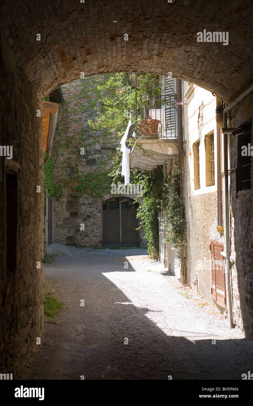 Vista a través de un arco a old street scene en Bérgamo, Italia. Foto de stock