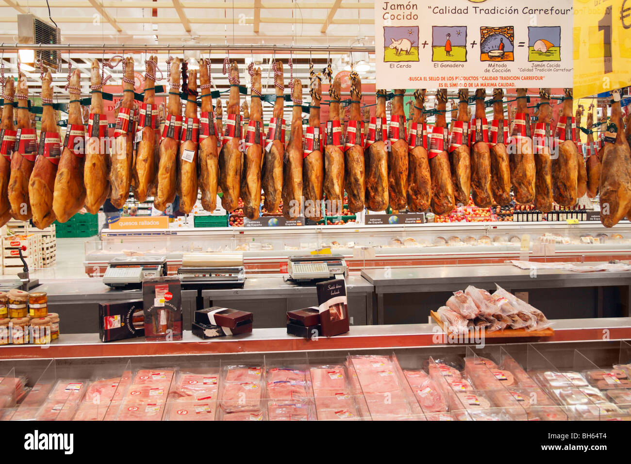 Jamon Iberico. Jamones colgando en el supermercado Carrefour en España Foto de stock