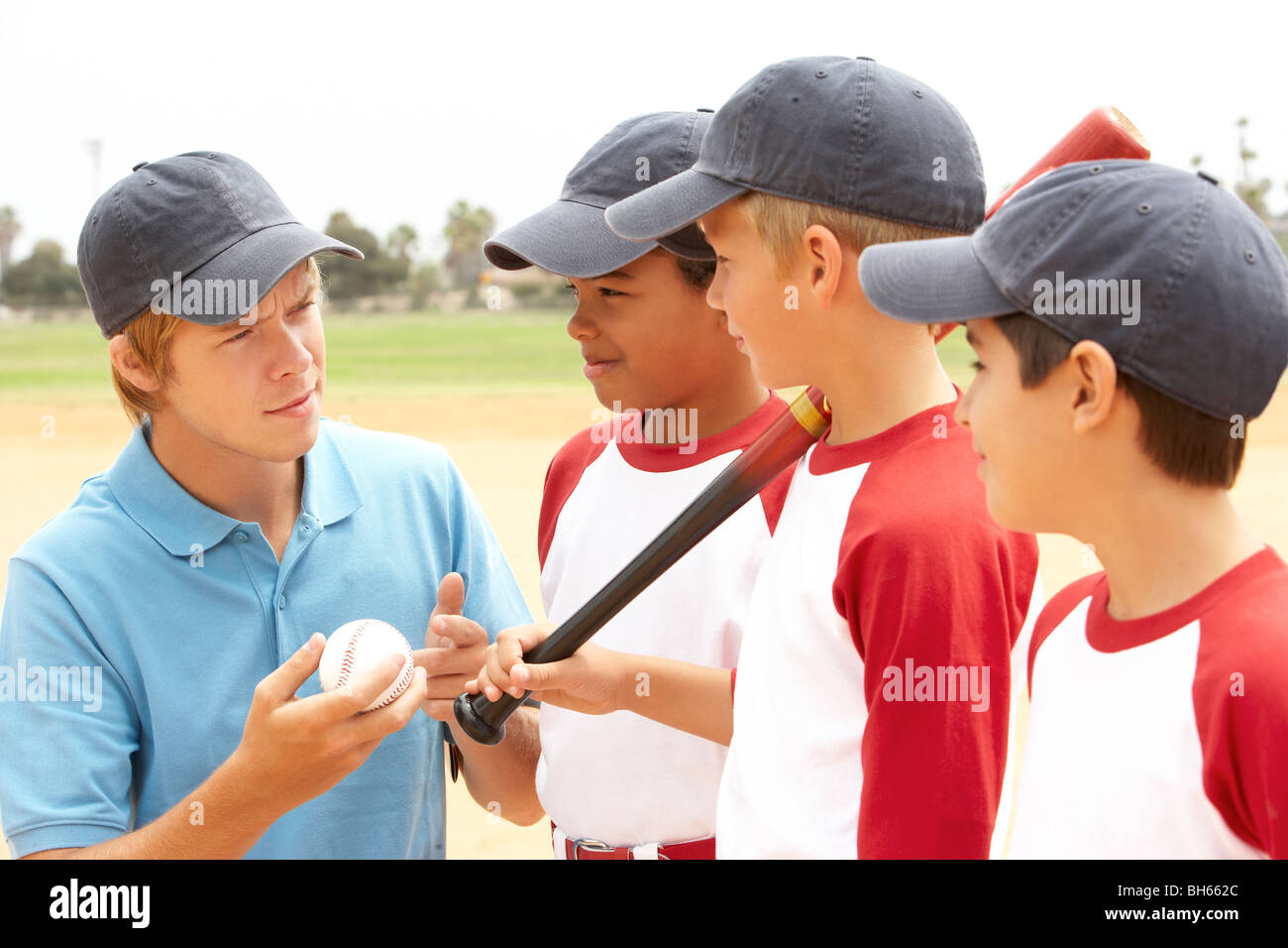 Los muchachos en el equipo de béisbol con el entrenador Foto de stock