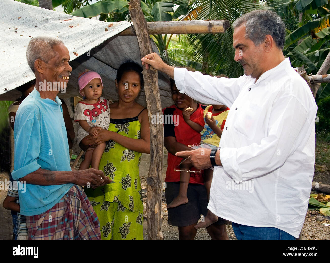 El presidente de Timor Oriental José Ramos-Horta "del pueblo" habla con la familia de un carpintero en aldea Liquicia Foto de stock