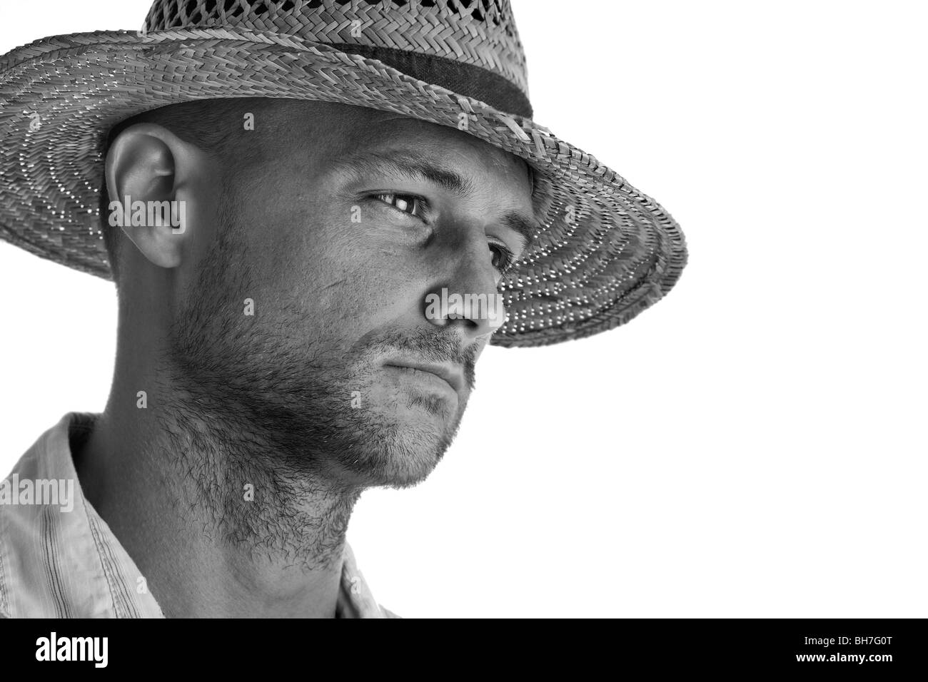 Retrato de un hombre en un sombrero de paja, con un estudio de fondo blanco, en atractivo mono Foto de stock