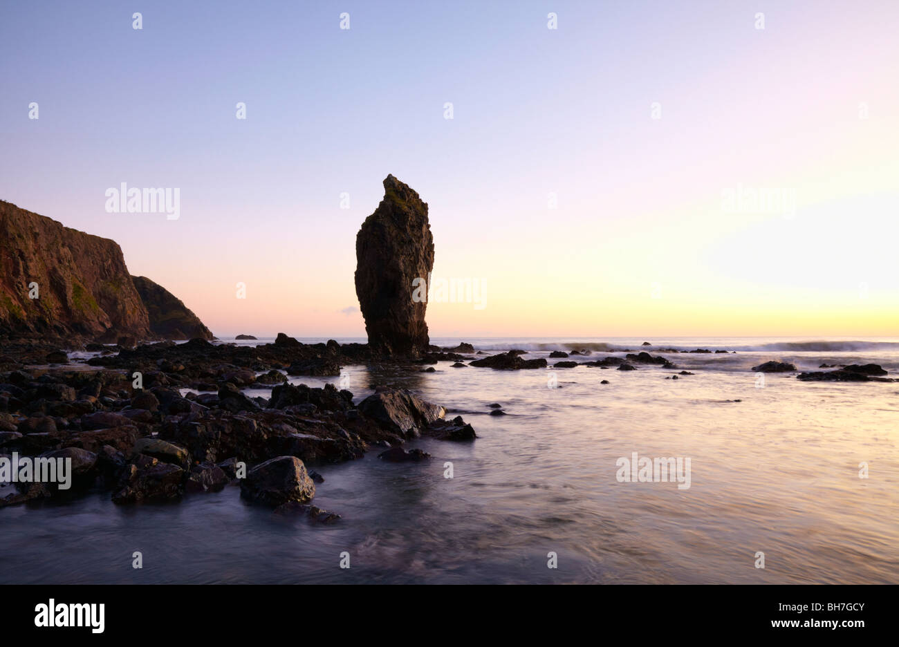 Gran roca está de guardia a la entrada a Ballyduane Cove en Costa Waterford Foto de stock