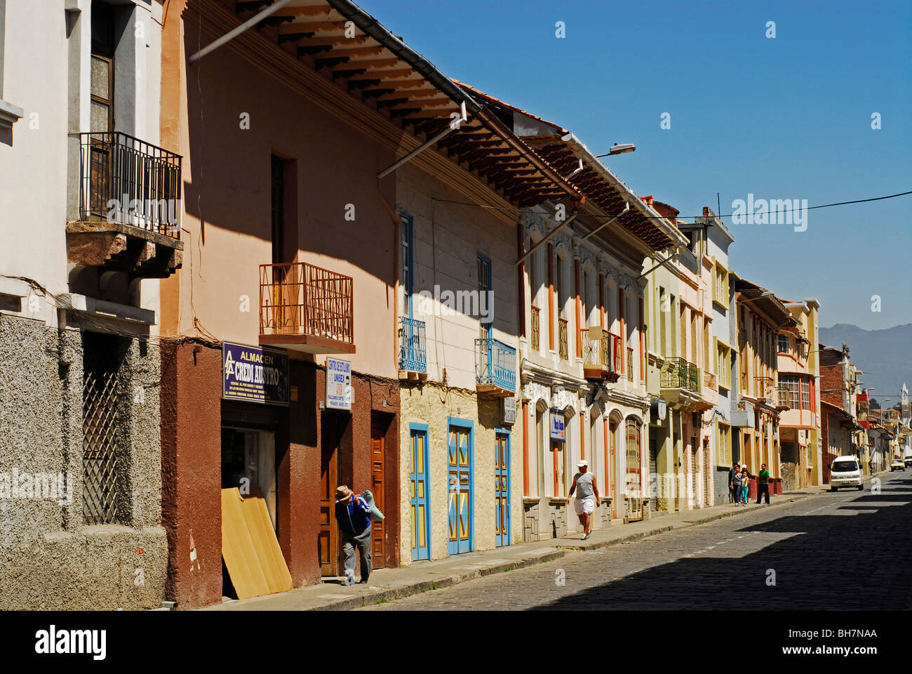 Ecuador, Cuenca, ángulo de visión baja de una calle con arquitectura  tradicional: dos pisos con balcones y gente en el ba Fotografía de stock -  Alamy