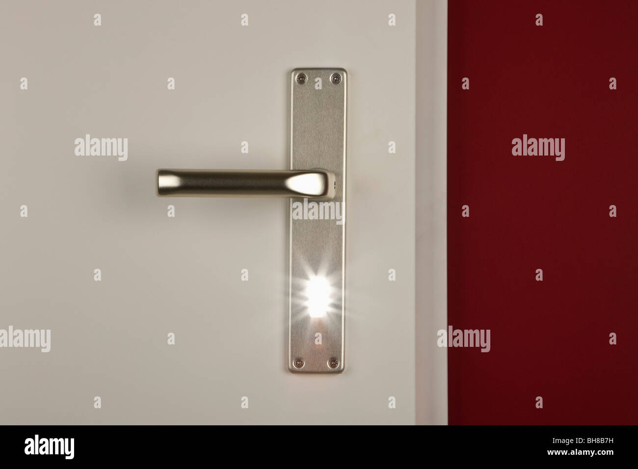 Detalle de una luz que brilla a través de la cerradura de la puerta Foto de stock