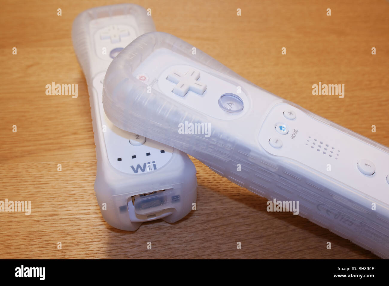Dos microteléfonos en Nintendo Wii protectores de goma sobre una superficie de madera Foto de stock