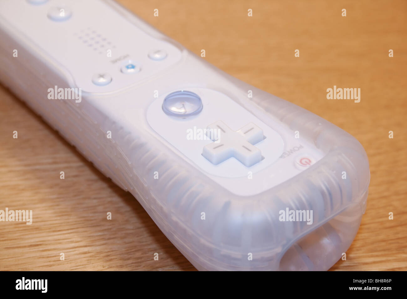 Nintendo Wii auricular en el manguito de goma en la superficie de madera Foto de stock
