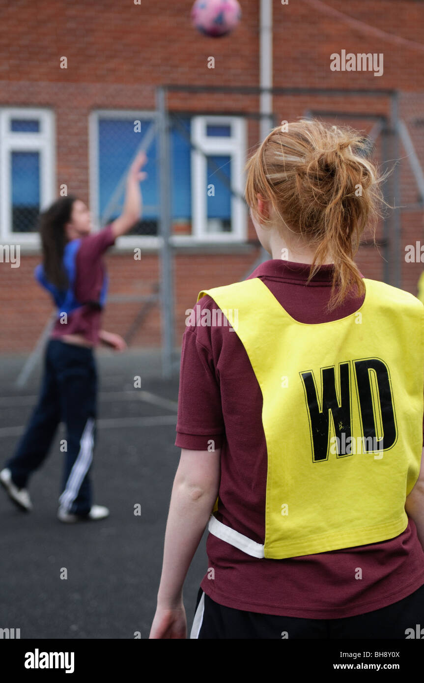 Las adolescentes jugando baloncesto, educación física, deportes y juegos, PE lección, escuela secundaria, Gales, Reino Unido Foto de stock