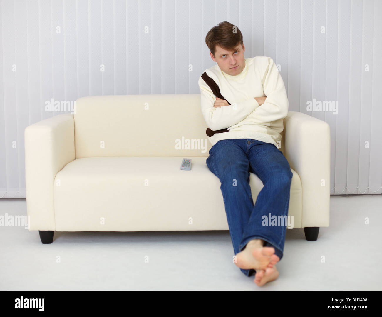 Un sombrío hombre sentado en el sofá frente al televisor Fotografía de  stock - Alamy