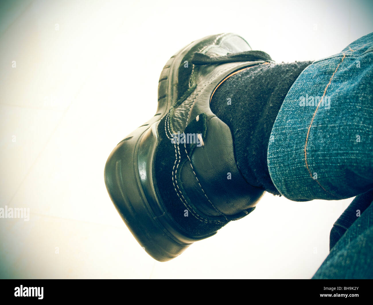 Hombre sentado con una pierna cruzada sobre la otra Fotografía de stock