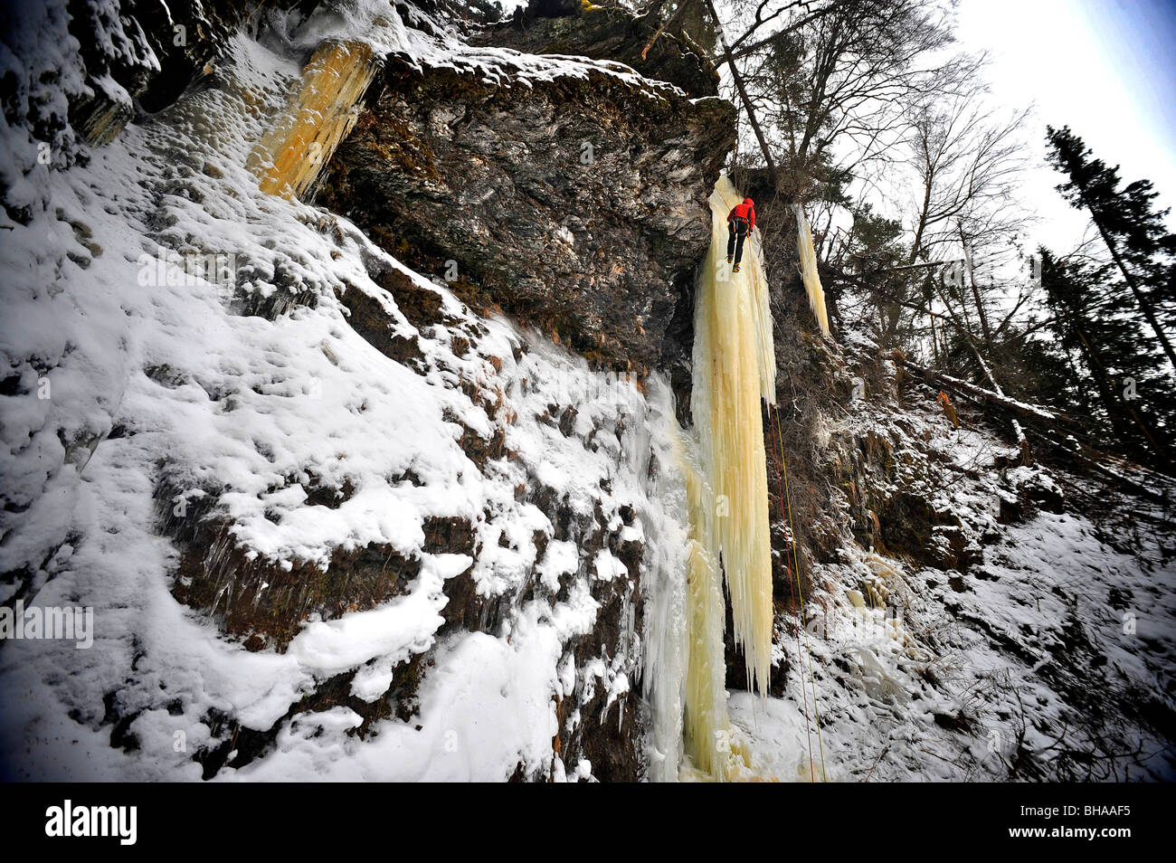 Mujer ice climber sube un gran icefall en Southcentral Alaska Foto de stock