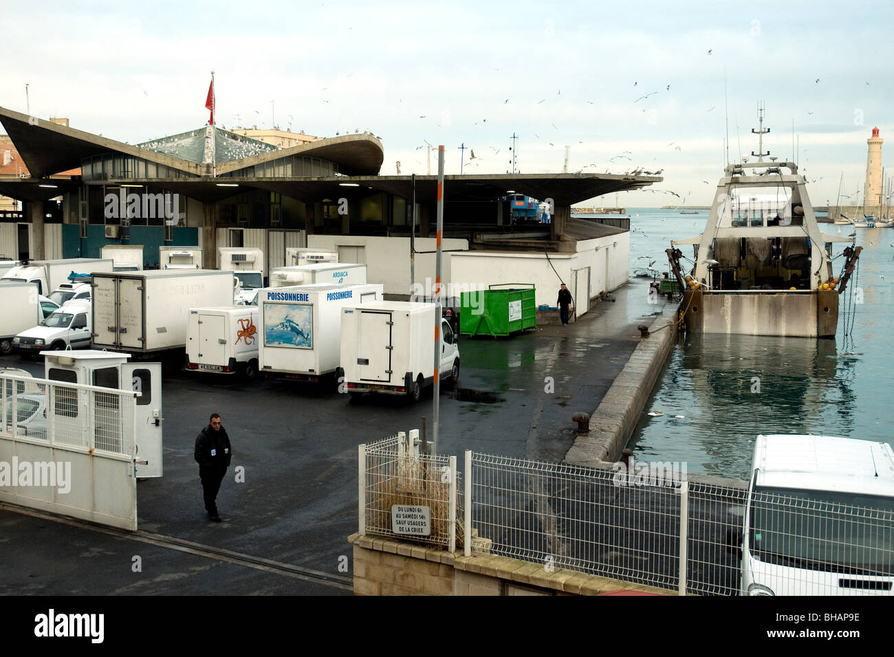 En Sète, Francia, el mayor puerto pesquero del Mediterráneo, un arrastrero moros junto a la subasta de pescado del puerto muelle cuando se aproxima la noche Foto de stock