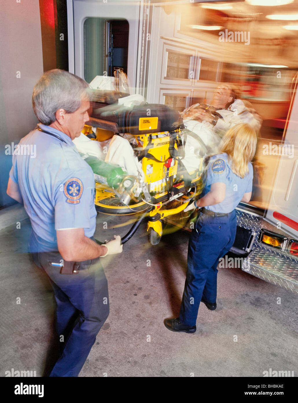 Los técnicos médicos de urgencias cargando paciente en ambulancia Foto de stock