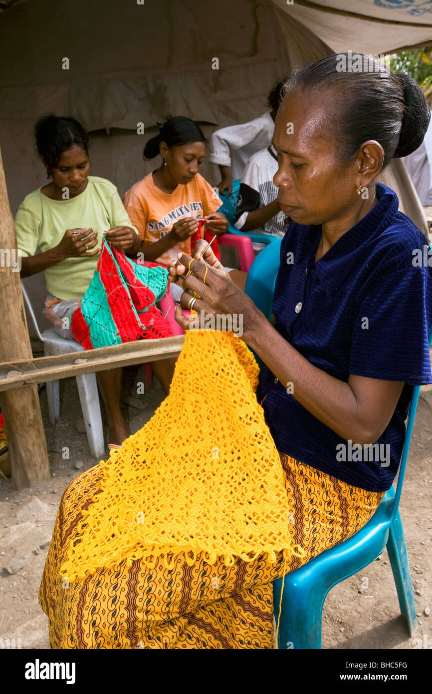 Las mujeres de la aldea empobrecida en una organizada comunidad negra clase para ganar algún dinero de Timor Oriental Foto de stock