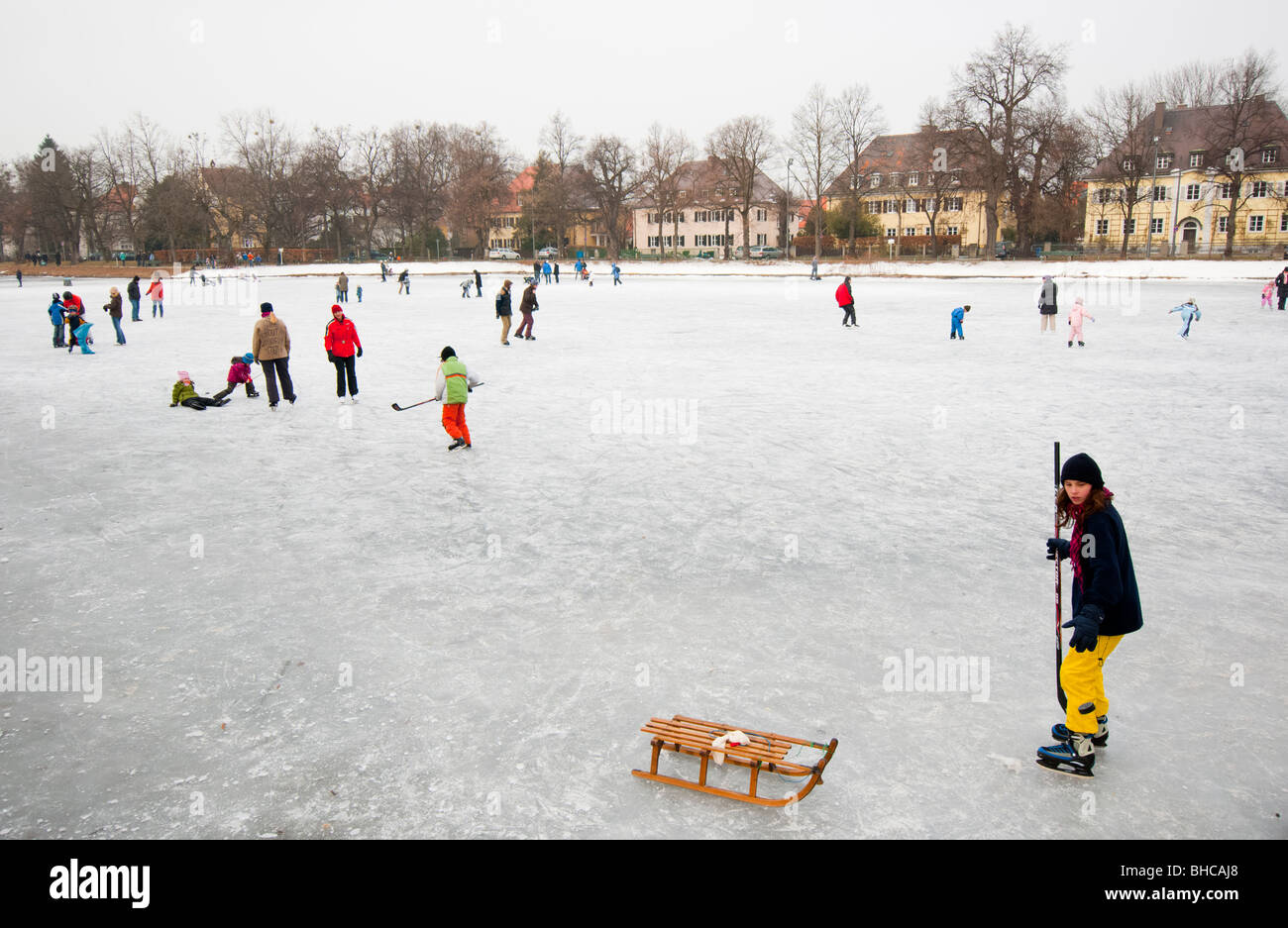 Los niños divertirse jugando al hockey sobre hielo en el lago congelado cerca de Palacio de Nymphenburg en Munich. Alemania. Foto de stock